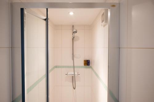 a shower with a glass door in a bathroom at The Brewer's House in Southwold