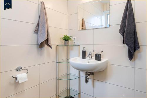 baño con lavabo y estante de cristal en Kimpi 1, en Ostseebad Koserow
