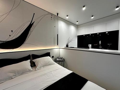 sypialnia z łóżkiem i ścianą z obrazem w obiekcie ЖК Atmosfera с парком на крыше в Аркадии w Odessie