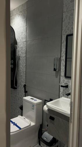 a bathroom with a white toilet and a sink at شاليهات مدينة الحدائق لبيوت العطلات in Baljurashi
