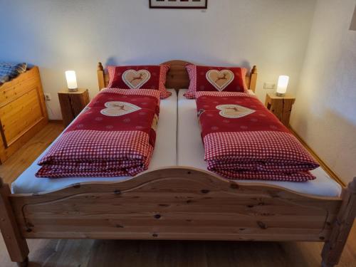 two beds with red pillows with hearts on them at Ferienwohnung Schindler in Nittenau