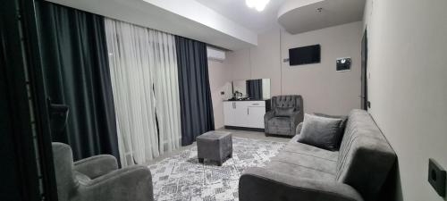 a living room with a couch and two chairs at Mersin Panorama Otel in Kargipınarı
