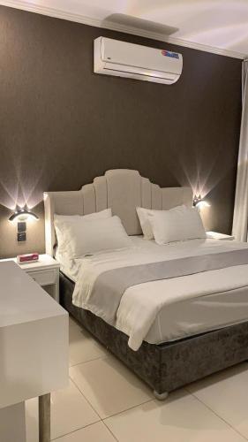a bedroom with a large bed with a air conditioner at شاليهات مدينة الحدائق لبيوت العطلات in Baljurashi