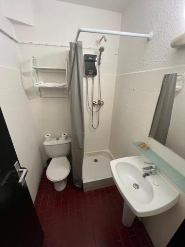 a small bathroom with a toilet and a sink at Hôtel La Palmeraie in Toulouse