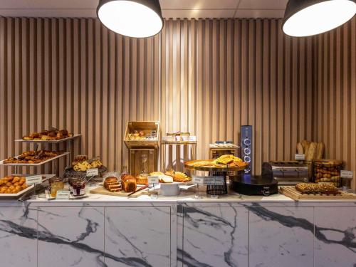 a buffet line with many different types of pastries at Mercure Nancy Centre Gare in Nancy