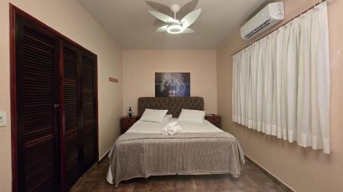 Un dormitorio con una cama y un ventilador de techo. en Refúgio nas Montanhas com Vista Deslumbrante, en Águas da Prata