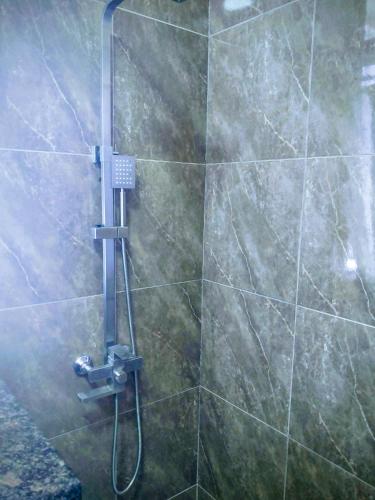 a shower with a hose in a bathroom at SéjourdétenteàMaurice in Albion