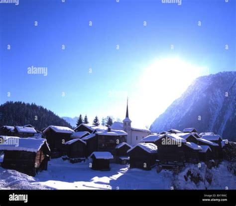 a group of buildings in the snow with a church at Swissalpschalet Timber Inn 1st floor, 6 persons in Blatten bei Naters