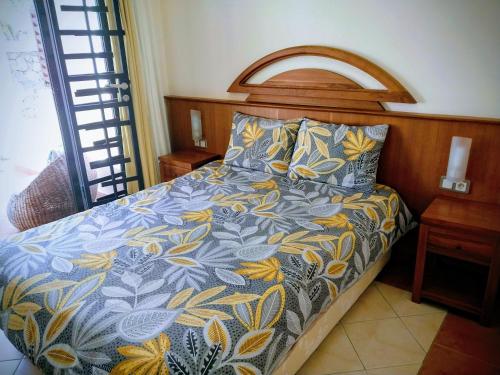 a bedroom with a bed with a blue and yellow bedspread at SéjourdétenteàMaurice in Albion