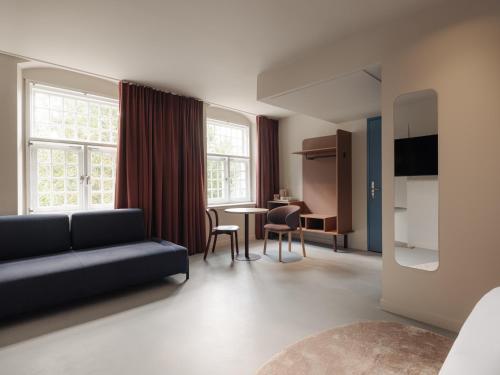 a living room with a couch and a table at Conscious Hotel Oudegracht in Utrecht