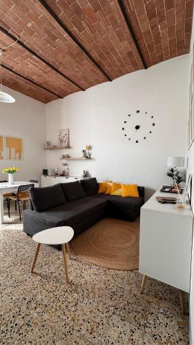 a living room with a black couch and a table at Cavour 21 Apartment in Certaldo