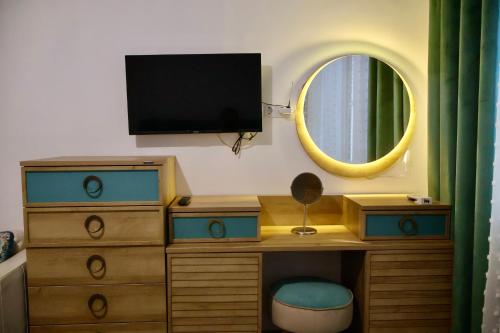 a bedroom with a dresser with a tv and a mirror at Casa Centrale with Free Parking in Plovdiv