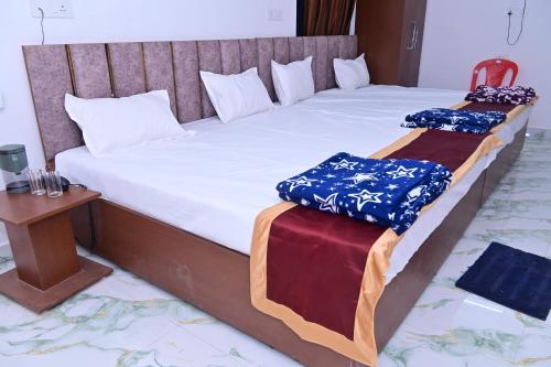 two twin beds in a room with a table at Hotel Neelkanth Palace in Naimishāranya