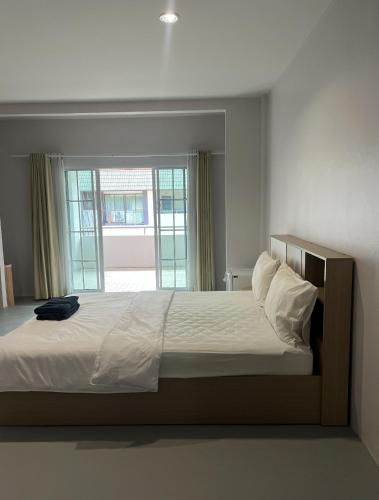 a bedroom with a large bed with a window at Hongheng Beach Residence - Walk to Jomtien & Night Market ! in Jomtien Beach