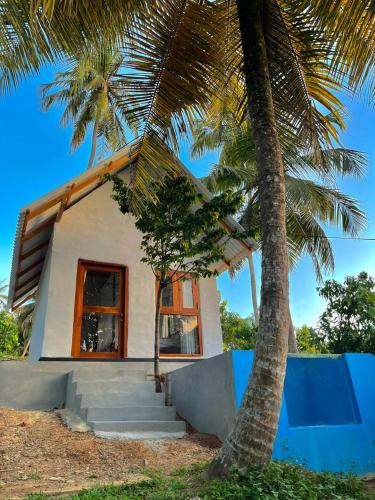a house with a palm tree in front of it at Kurundu House Mirissa in Mirissa