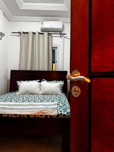 un dormitorio con una cama y una ventana en Appart chic à Bonapriso, en Douala