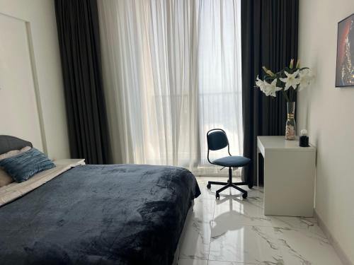 a bedroom with a bed and a chair in front of a window at Marina Al Hamra in Ras al Khaimah