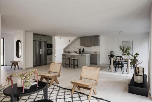 Newly built Scandinavian villa in Gothenburg في Hällsvik: غرفة معيشة بيضاء مع كراسي وطاولة