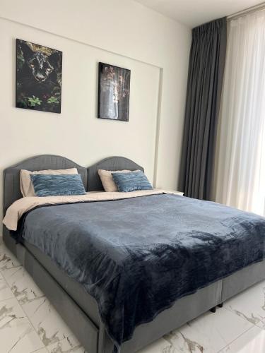 a bedroom with a large bed with blue sheets at Marina Al Hamra in Ras al Khaimah