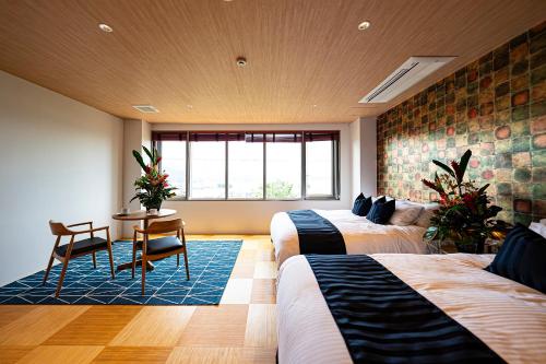 a bedroom with two beds and a table and a window at Angelroad Hotel in Tonosho