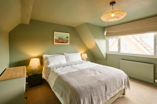 a bedroom with a white bed and a window at The Beach House in Overstrand