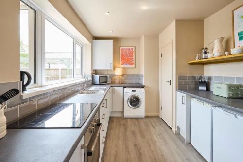 a kitchen with a washer and dryer in it at The Beach House in Overstrand