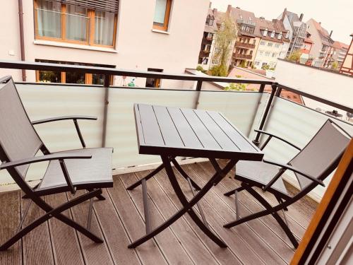 a picnic table and two chairs on a balcony at 2-Zimmer Wohnung direkt in der Altstadt in Nürnberg