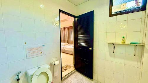 a bathroom with a toilet and a black door at Charming Guest Room in Central Pa Tong, Thailand in Patong Beach