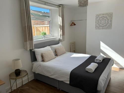 een slaapkamer met een bed met witte lakens en een raam bij Parkside Apartment in Norwich