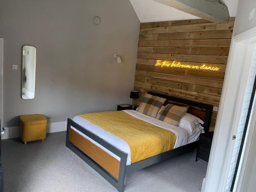 a bedroom with a bed with a wooden headboard at The White Horse in Shipston on Stour