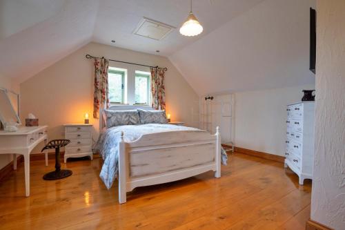 a bedroom with a bed and a desk and a window at Finest Retreats - Rough Close Farm Cottage in Ashover