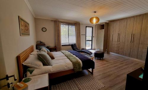 a bedroom with a large bed and a living room at Stay at 64 Omeya in Windhoek