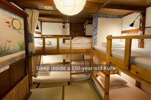 a room with three bunk beds in it at Kanazawa Guesthouse Pongyi in Kanazawa