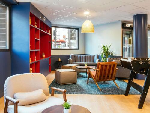 a waiting room with chairs and a couch and tables at Aparthotel Adagio Paris Malakoff Chatillon in Malakoff
