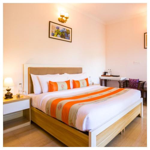 een slaapkamer met een groot bed met oranje kussens bij Sanskari Nivas family holiday home in Kasauli