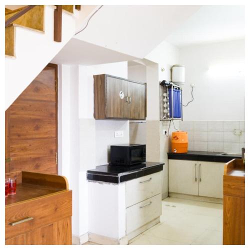 een keuken met een spoelbak en een magnetron bij Sanskari Nivas family holiday home in Kasauli