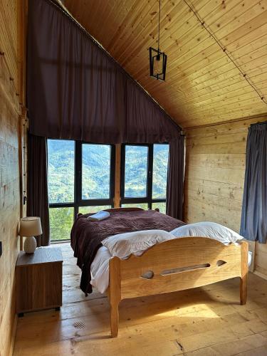 a bedroom with a large bed in a room with windows at GR Qobu merisi in Inasharidzeebi