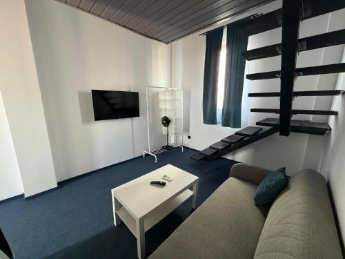 Una sala de estar con un sofá y un televisor. en Zoon In, en Costinesti