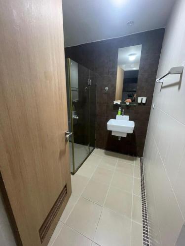 a bathroom with a sink and a mirror and a door at Studio in Haven in Bangkok