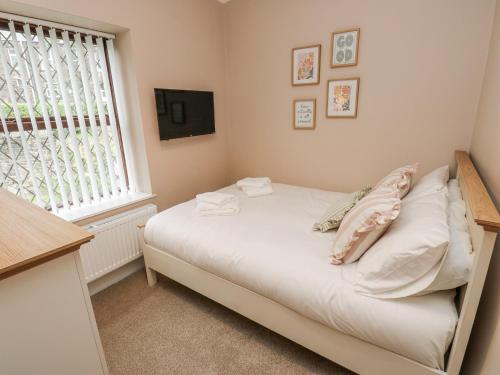 a small bedroom with a bed and a window at Court Street Cottage in Saddleworth