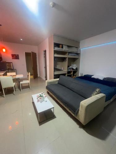 a bedroom with a bed and a living room with a table at Studio in Haven in Bangkok