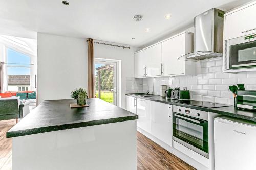 Una cocina con gabinetes blancos y encimera. en Bright & Spacious 2 Bed Holiday Chalet in Sidmouth, en Sidmouth