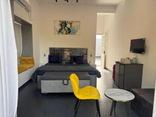 a bedroom with a bed and a yellow chair at Casa Oceanus - 3 Bedroom - Sea Facing Pool Villa - Ganpatipule in Ganpatipule