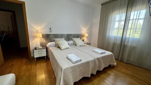 a bedroom with a large bed with two towels on it at Amanecer zen in Argés