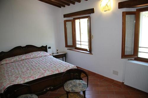 a bedroom with a bed and two windows at Borgo Fango in Montieri