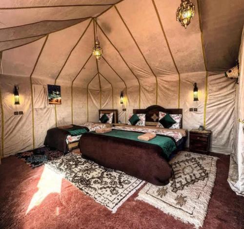a bedroom with a bed in a tent at Desert Marhaba luxury Camp in Merzouga