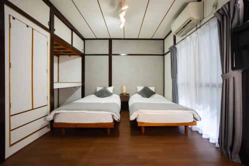 a bedroom with two beds and a window at SORAHOME Direct access to city Manga & bicycle included in Tokyo