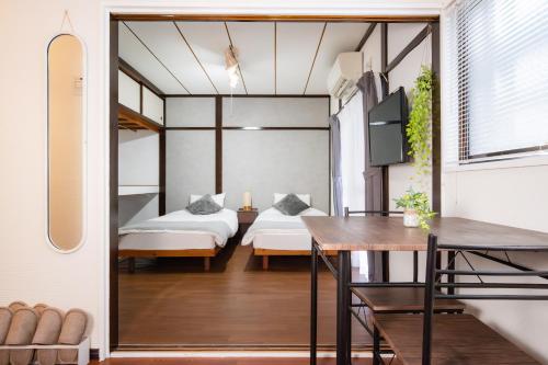 a room with two beds and a table and a dining room at SORAHOME Direct access to city Manga & bicycle included in Tokyo