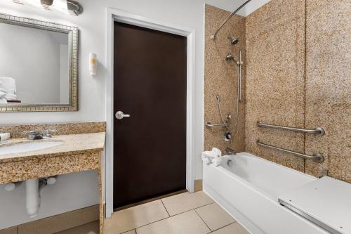 a bathroom with a tub and a sink and a shower at Comfort Inn & Suites Augusta West Near Fort Gordon in Augusta
