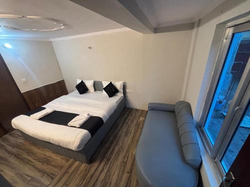 a small room with a bed and a couch at The Mist Nainital Hotel in Nainital